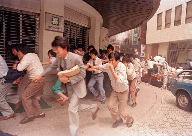 Protesters fleeing after riot police hurled tear gas to break up a march in central Seoul during the nationwide June Democratic Struggle, as demonstrators attempted to march toward Myeongdong Cathedral to support students staging a pro-democracy sit-in. (1987)